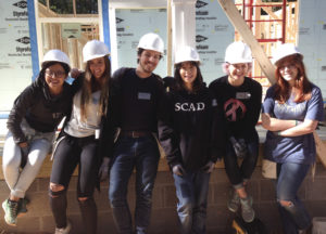 Some of the student volunteers from SCAD Atlanta pose for a picture at the construction site. The students spent more than eight hours helping build the house with Habitat for Humanity. Photo by Gio Turra.